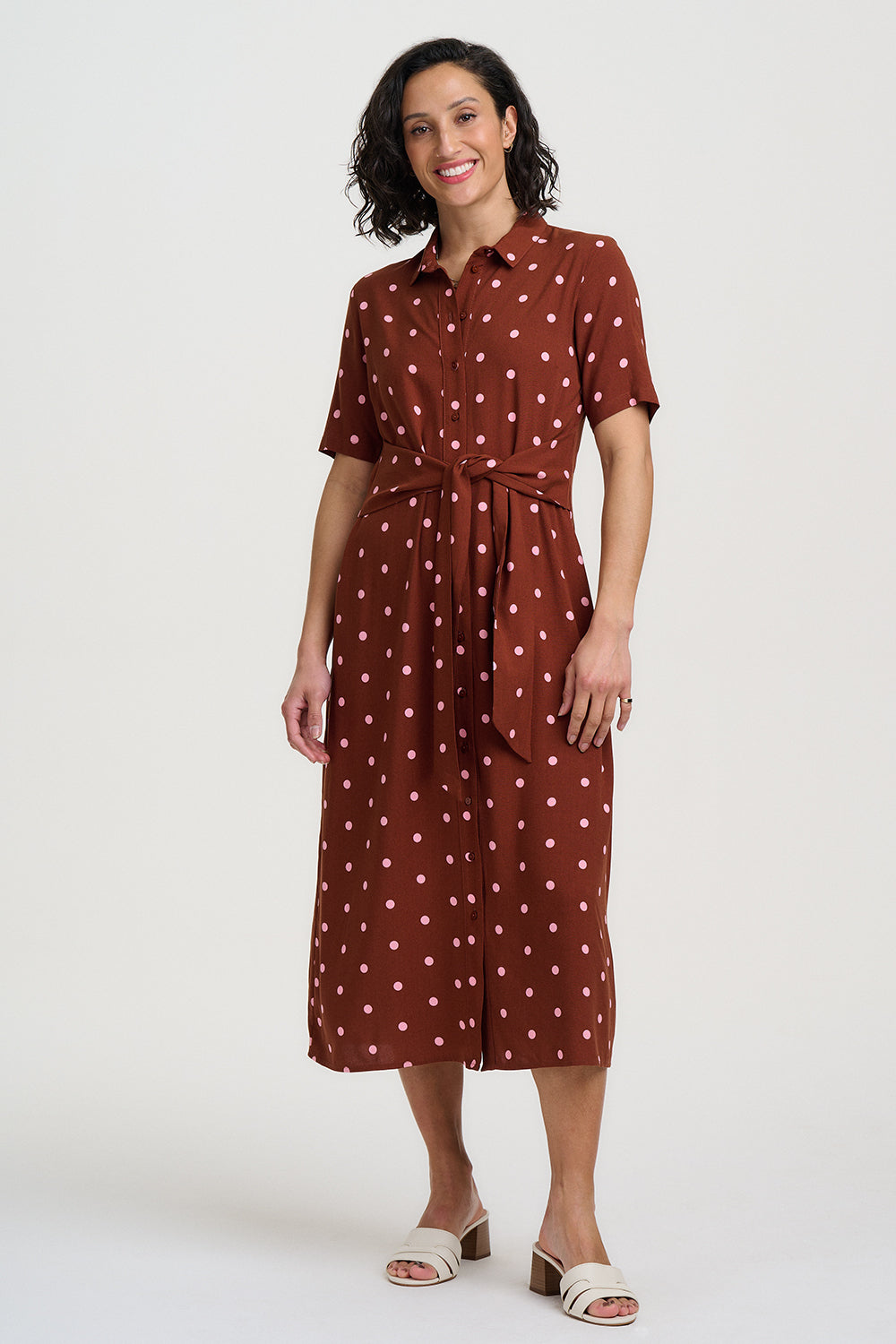 Brown dress with pink polka dots on a white background
