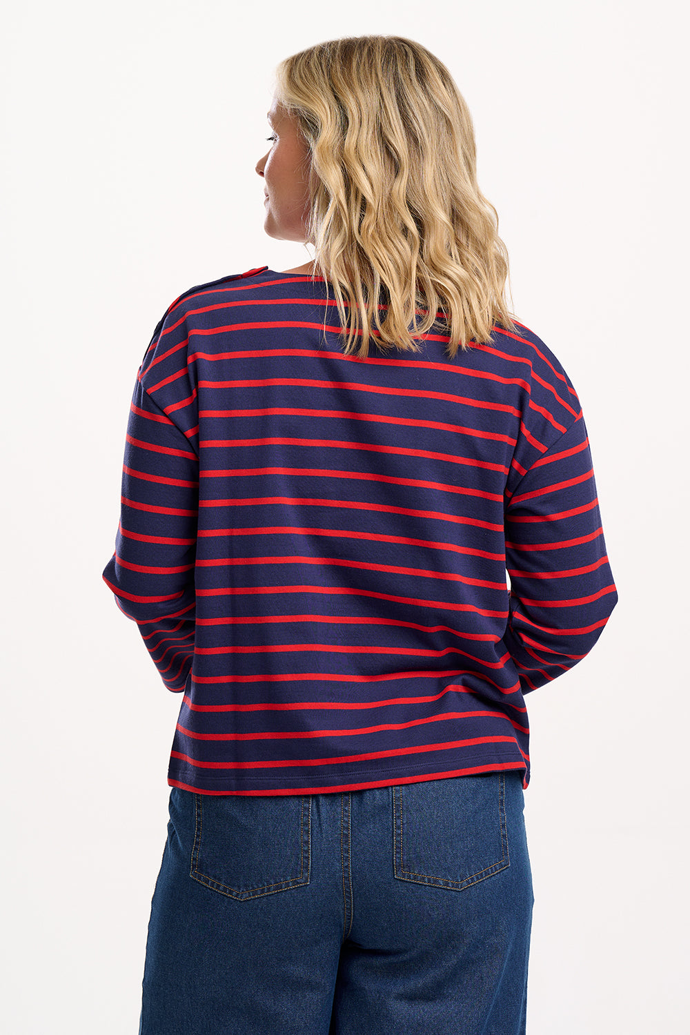 Sugarhill Brighton model wearing a red and blue striped shirt with blue jeans on a white background