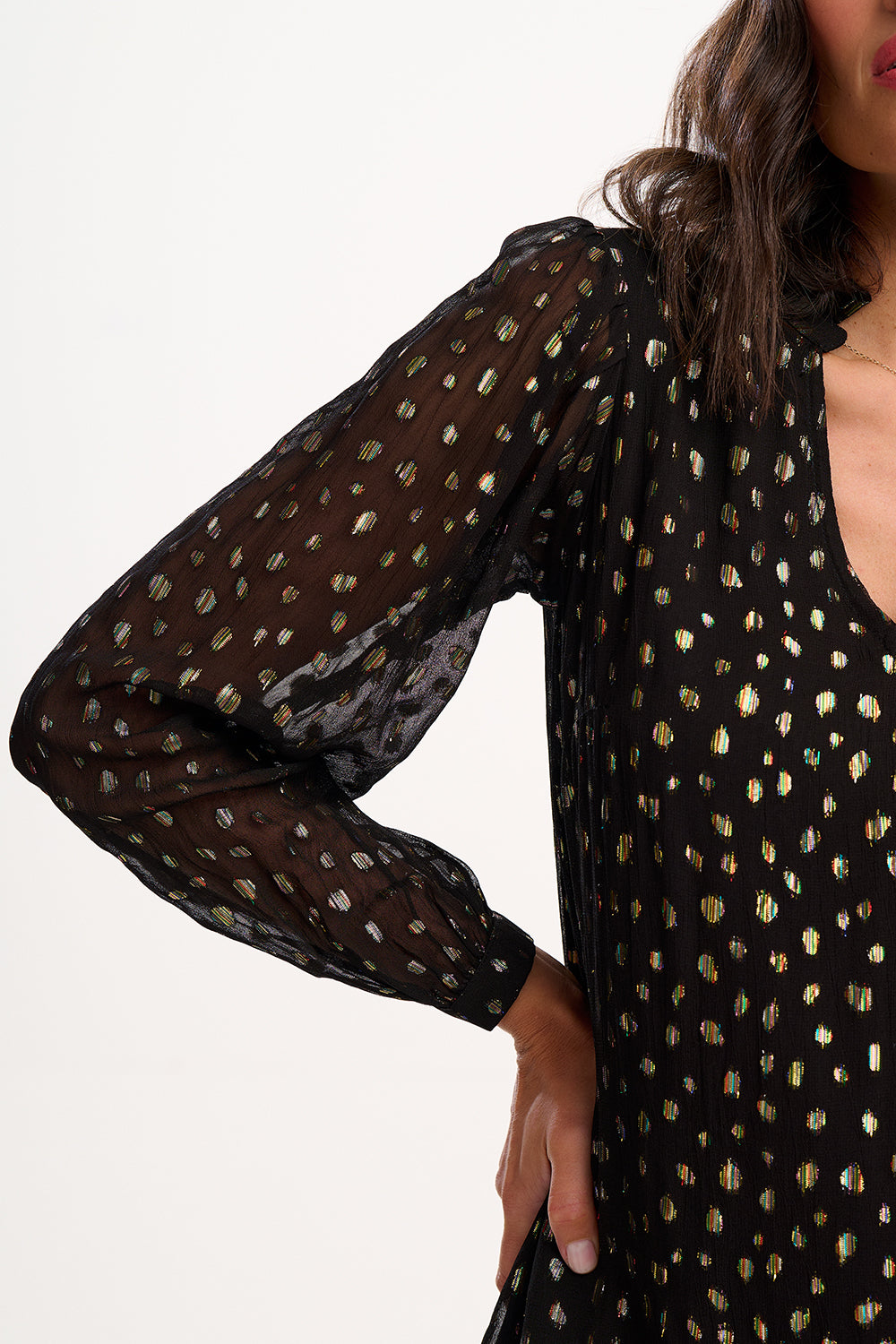 Black dress with gold polka dot pattern on a white background