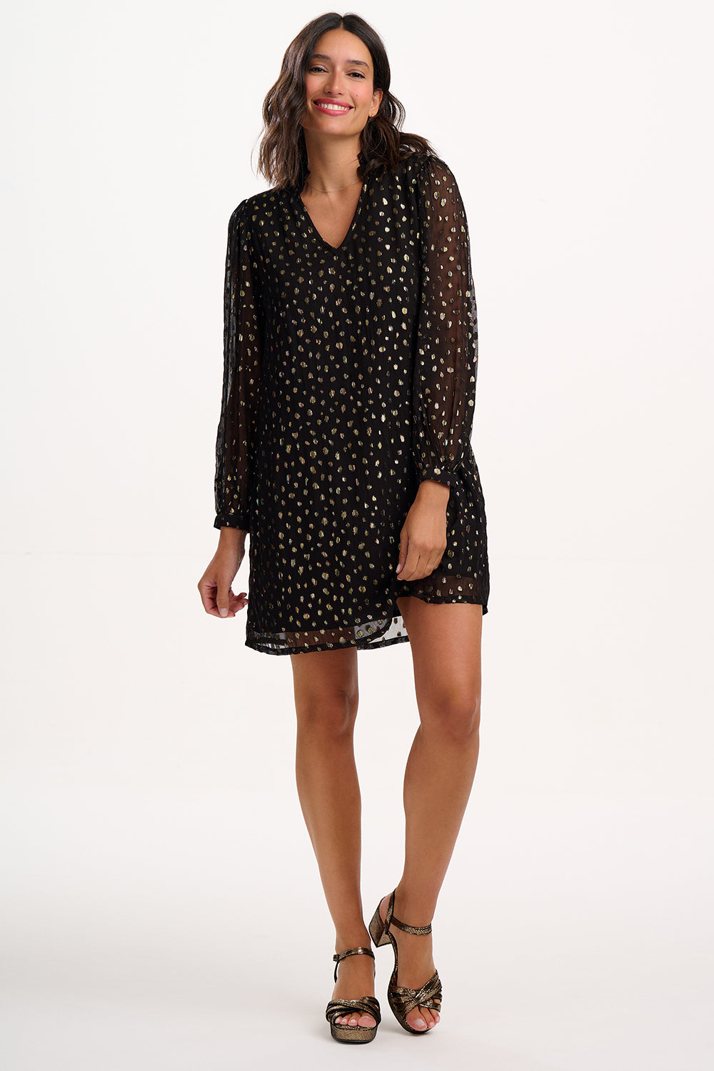 Woman wearing a black polka dot dress on a white background