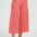 Person wearing coral wide-leg pants on a white background