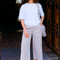 Woman wearing awhite tshirt and colorful striped pants