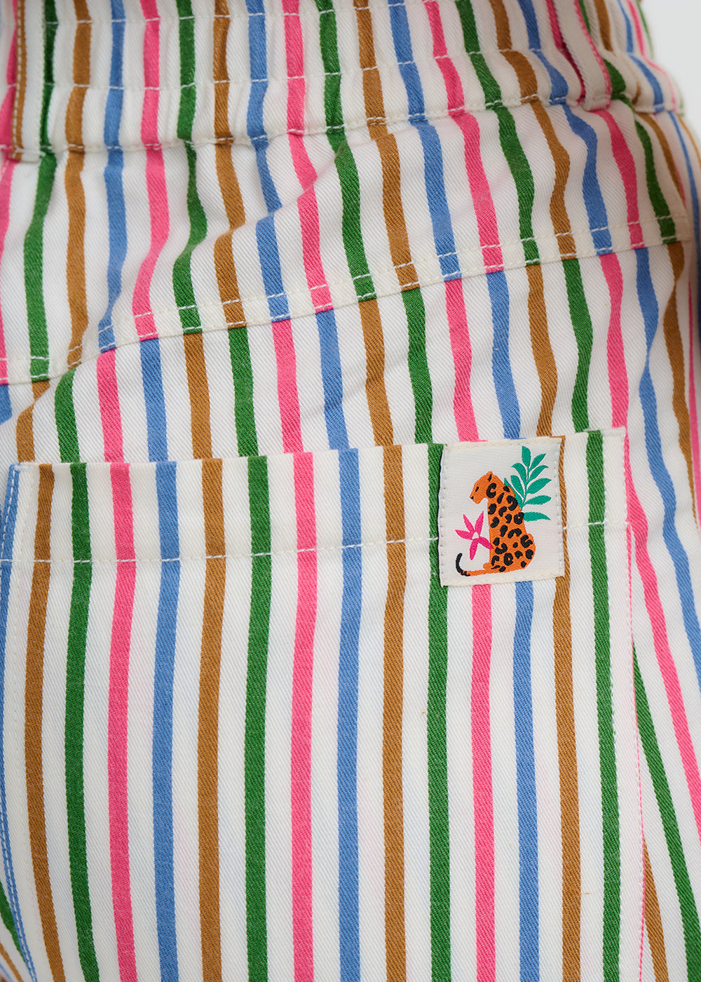 Colorful striped fabric with a small patch featuring a leopard design.