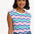 A woman smiling and wearing a sleeveless round neck t-shirt with a multicolored geometric pattern in shades of pink, green, and blue.