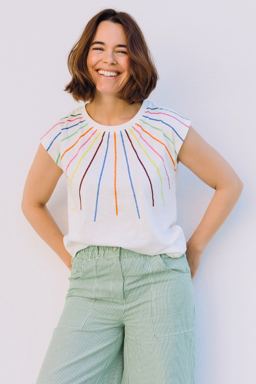 Woman wearing a colorful sleeveless top with a white background