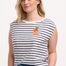 A woman wearing an off-white sleeveless tank top with navy stripes and a fruity orange embroidery on the chest.