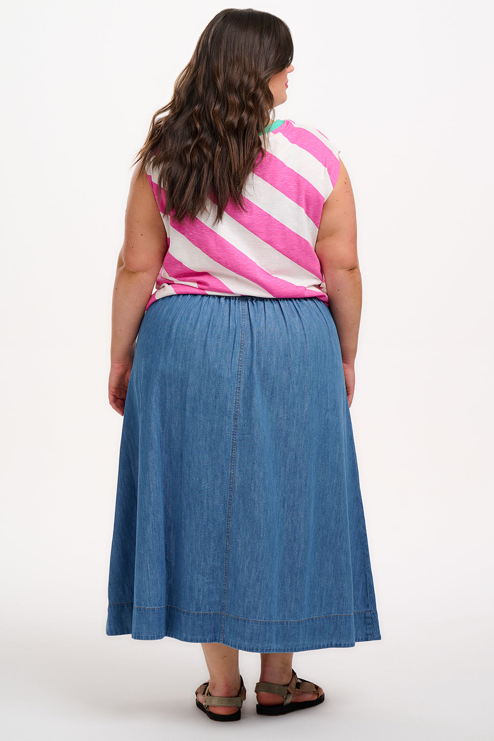 Sugarhill Brighton t-shirt. A female model wearing an oversized sleeveless striped t-shirt in pink and white, paired with blue jeans.