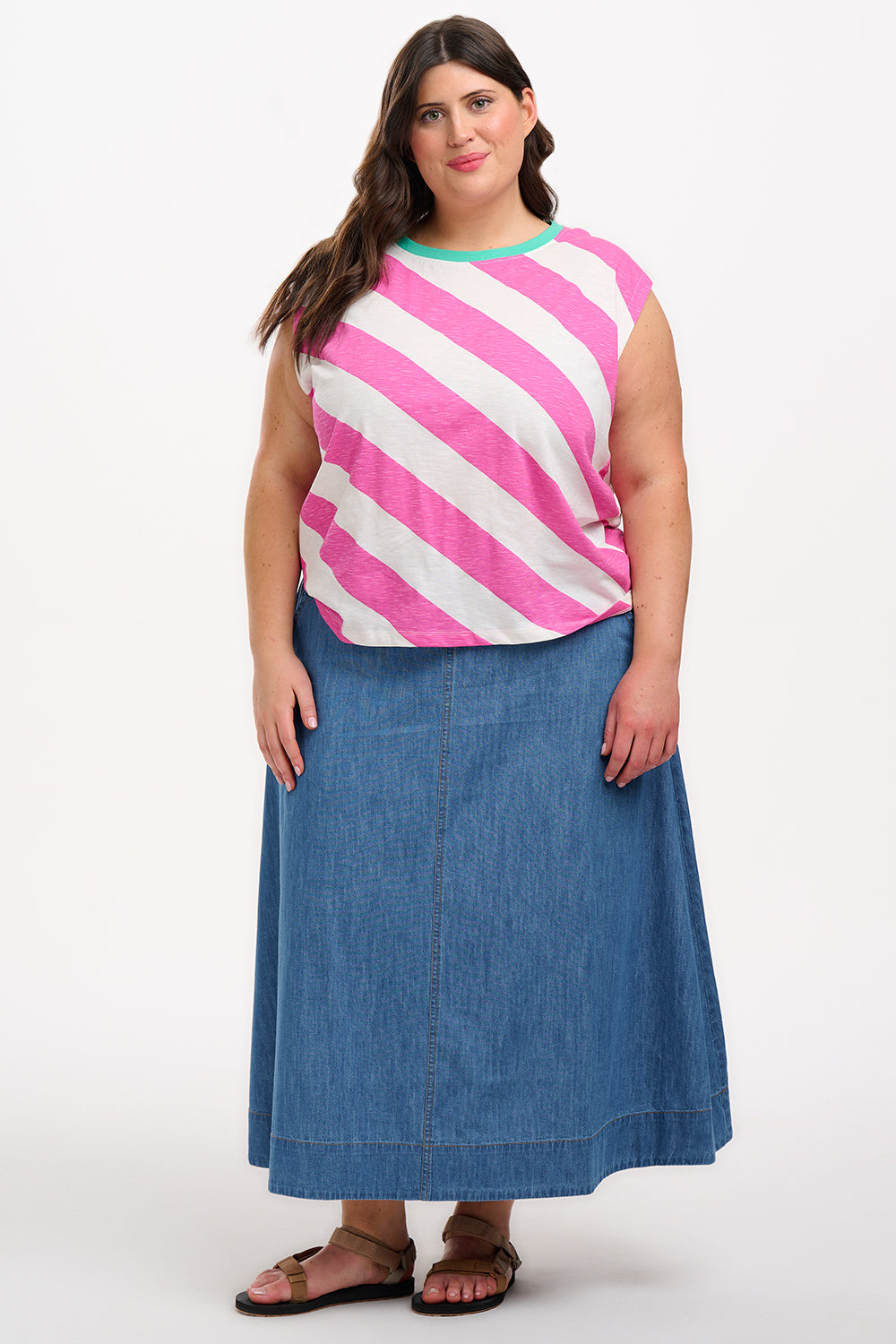 Sugarhill Brighton t-shirt. A female model wearing an oversized sleeveless striped t-shirt in pink and white, paired with blue jeans.