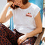 Woman wearing a white t-shirt with a colourful strawberry design