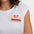 Woman wearing a white t-shirt with a colorful strawberry design on a plain background
