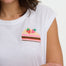 Woman wearing a white t-shirt with a colorful strawberry design on a plain background