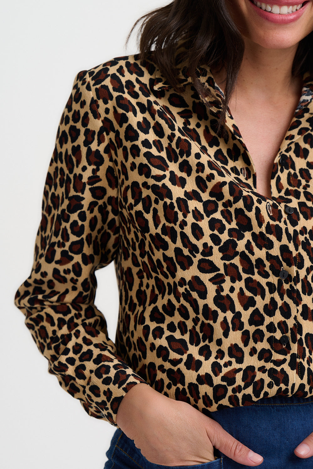 Leopard print blouse worn by a person on a white background