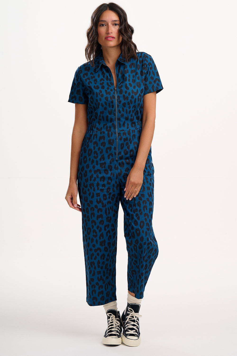 Woman wearing a blue patterned jumpsuit on a white background