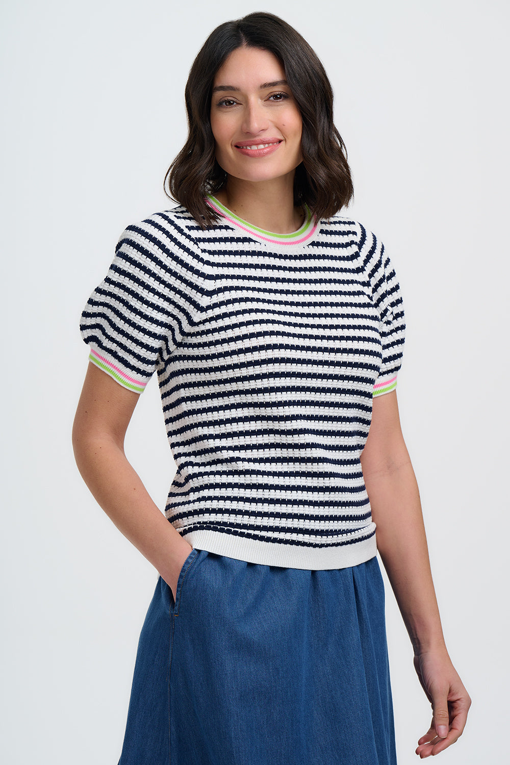 Woman wearing a black and white striped shirt with colorful trim on a white background