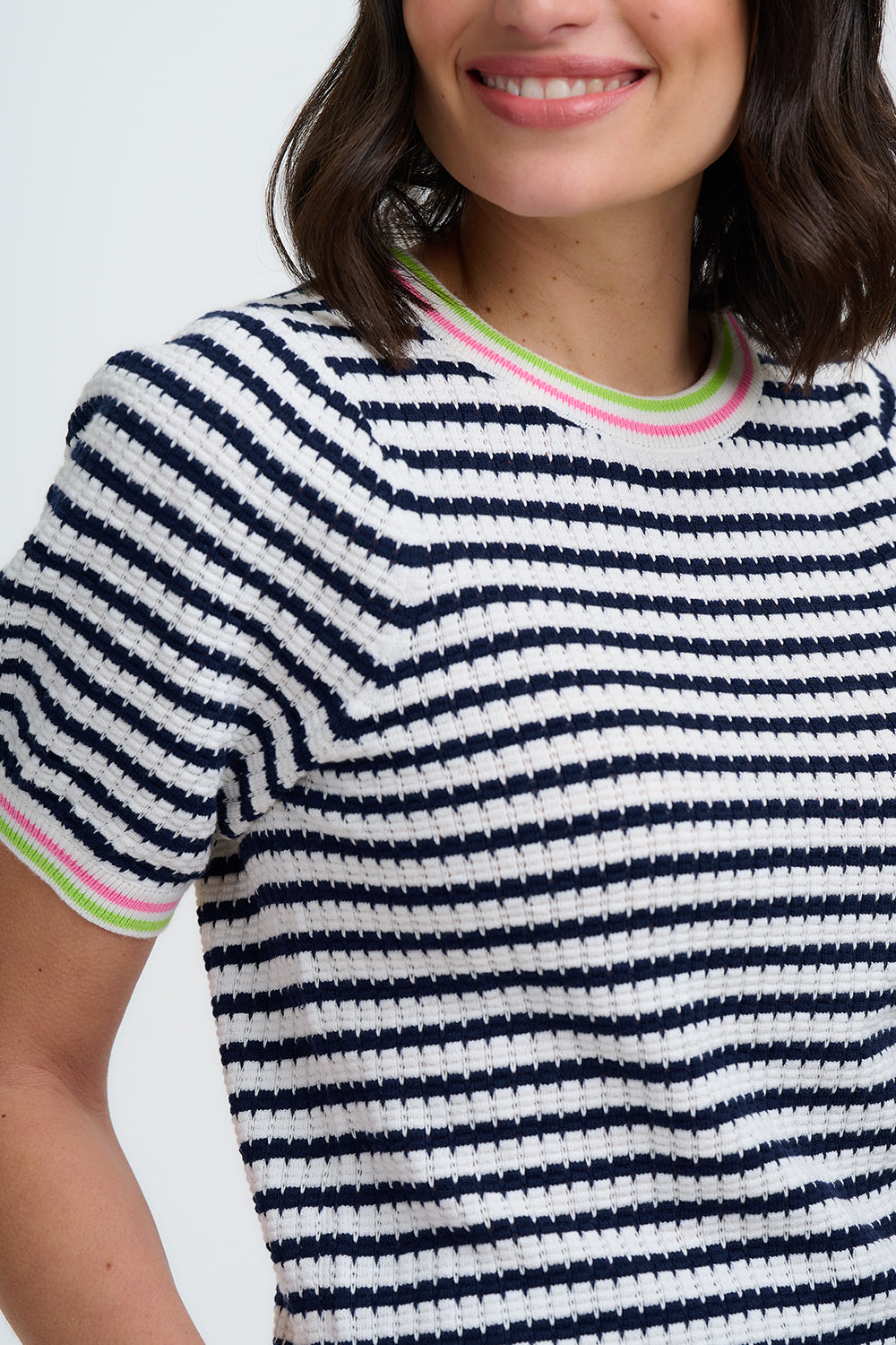 Close-up of a person wearing a navy and white striped shirt with colorful trim.