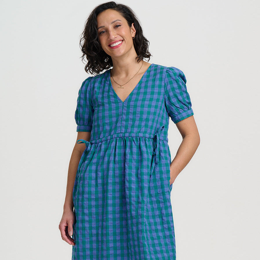 Woman wearing a blue checkered dress on a white background