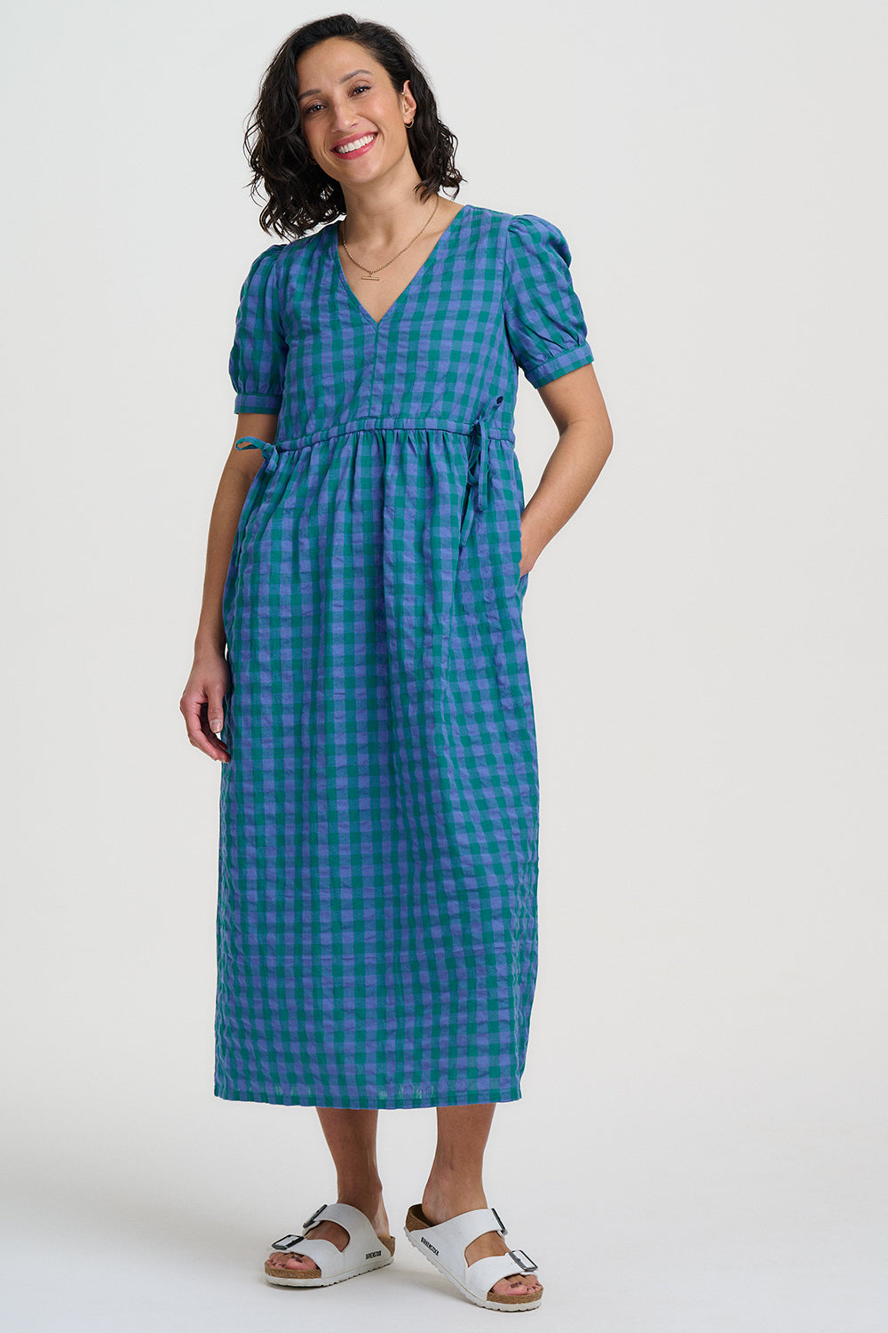 Woman wearing a blue checkered dress on a white background