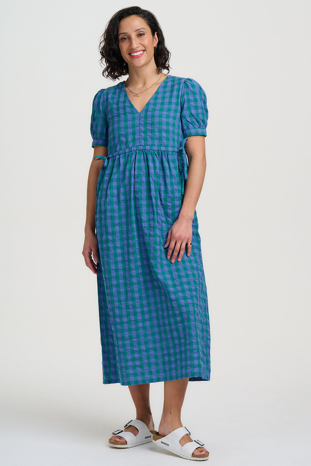 Woman wearing a blue checkered dress on a white background