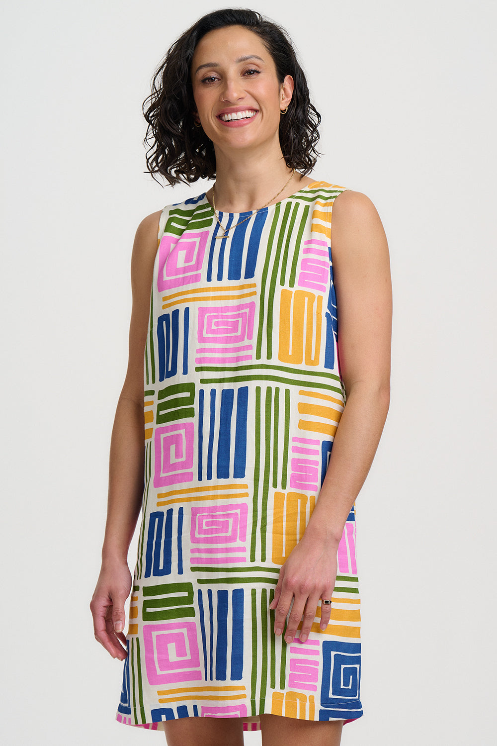 Woman wearing a colorful geometric patterned dress on a white background