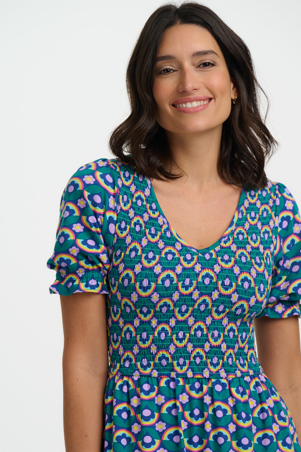 Woman wearing a colorful patterned dress on a white background