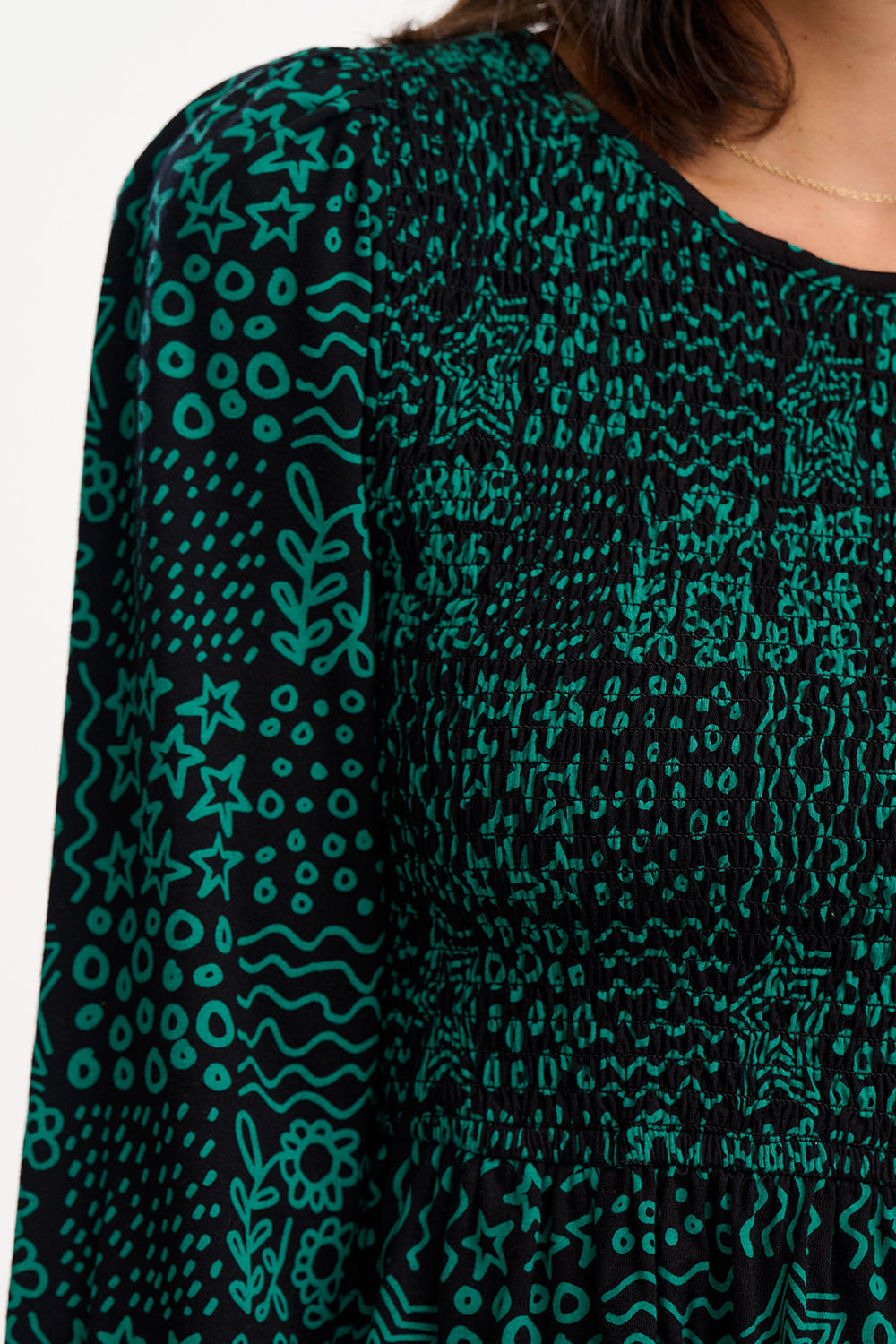 Green patterned dress with long sleeves on a white background