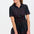 A woman wearing a knee-length black shirt dress with a multicolored polka dot pattern, short sleeves, and a tie-front belt.