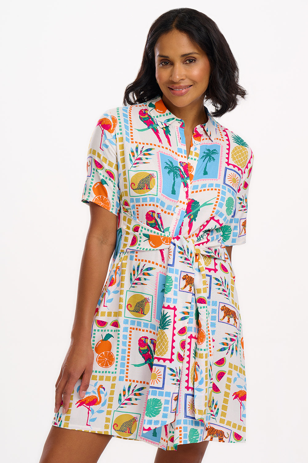 A model wearing a short-sleeved shirt dress with a tie-front belt and a multicolored jungle tile print.