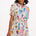 A model wearing a short-sleeved shirt dress with a tie-front belt and a multicolored jungle tile print.