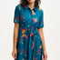 A model wearing a teal shirt dress with a Rainbow Parrots print, featuring short sleeves and a tie-front belt.