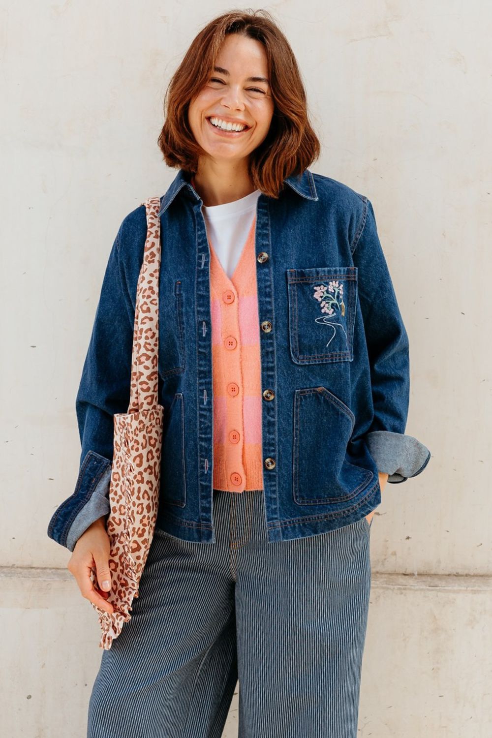 Woman wearing a denim jacket and jeans with a white background