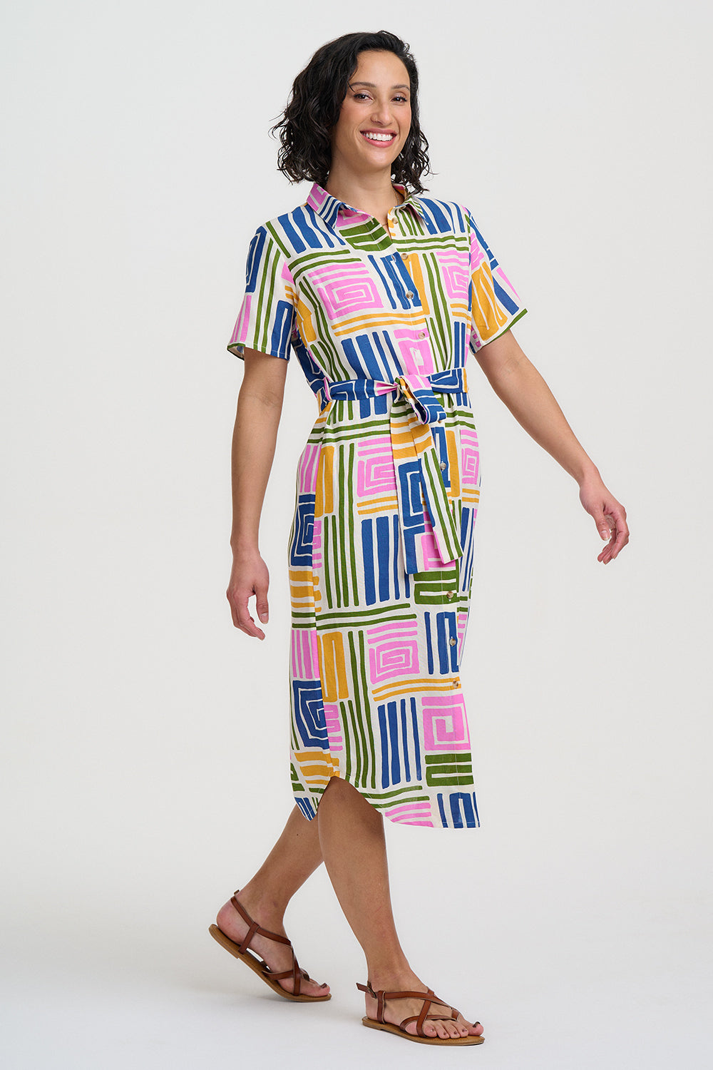 Woman wearing a colorful geometric patterned dress on a white background