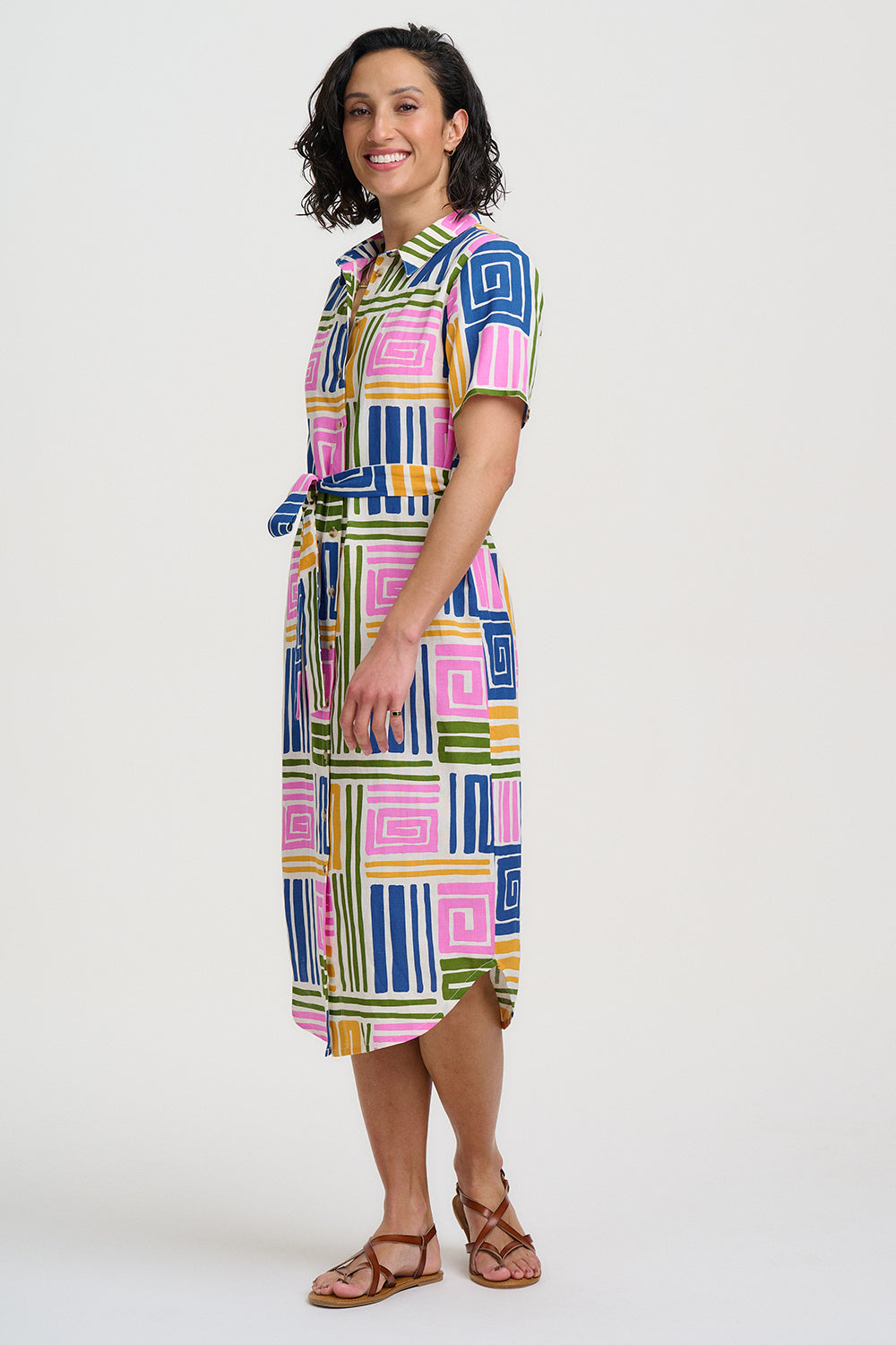 Woman wearing a colorful geometric patterned dress on a white background