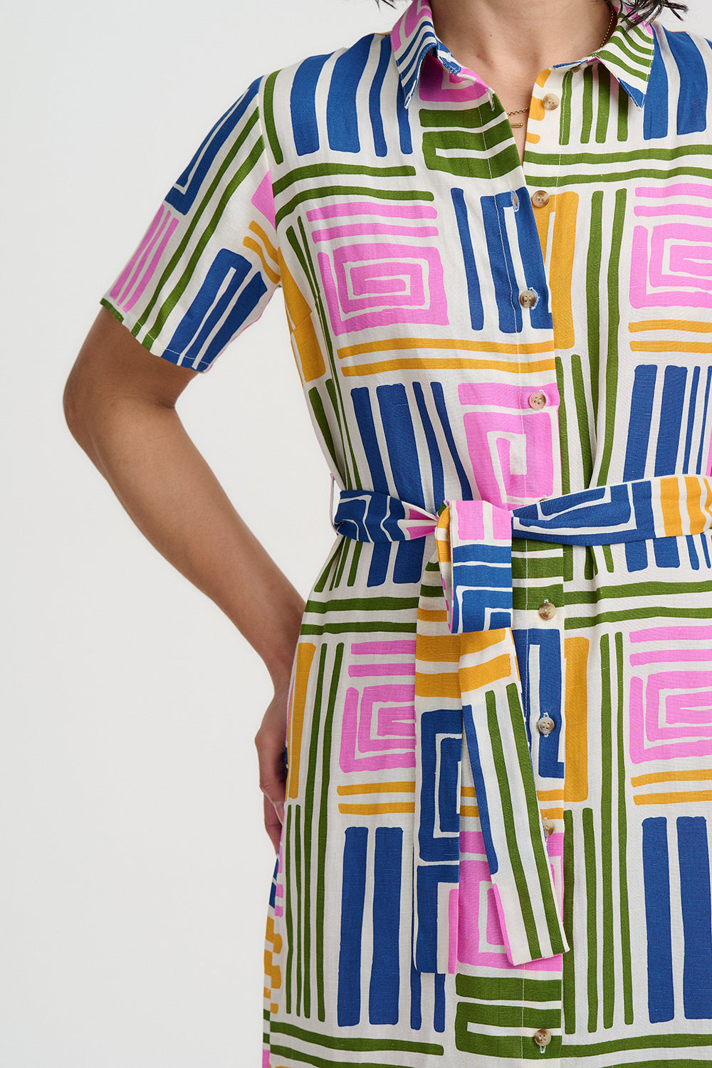 Colorful geometric patterned dress on a plain background