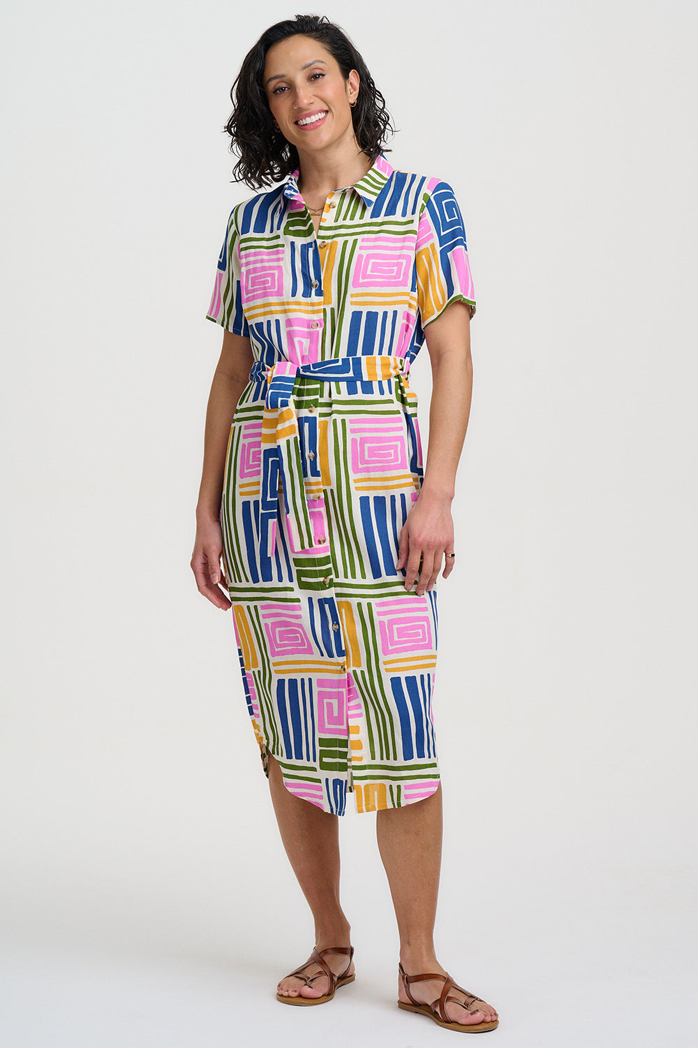 Woman wearing a colorful geometric patterned dress on a white background