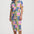Woman wearing a colorful geometric patterned dress on a white background
