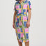 Woman wearing a colorful geometric patterned dress on a white background