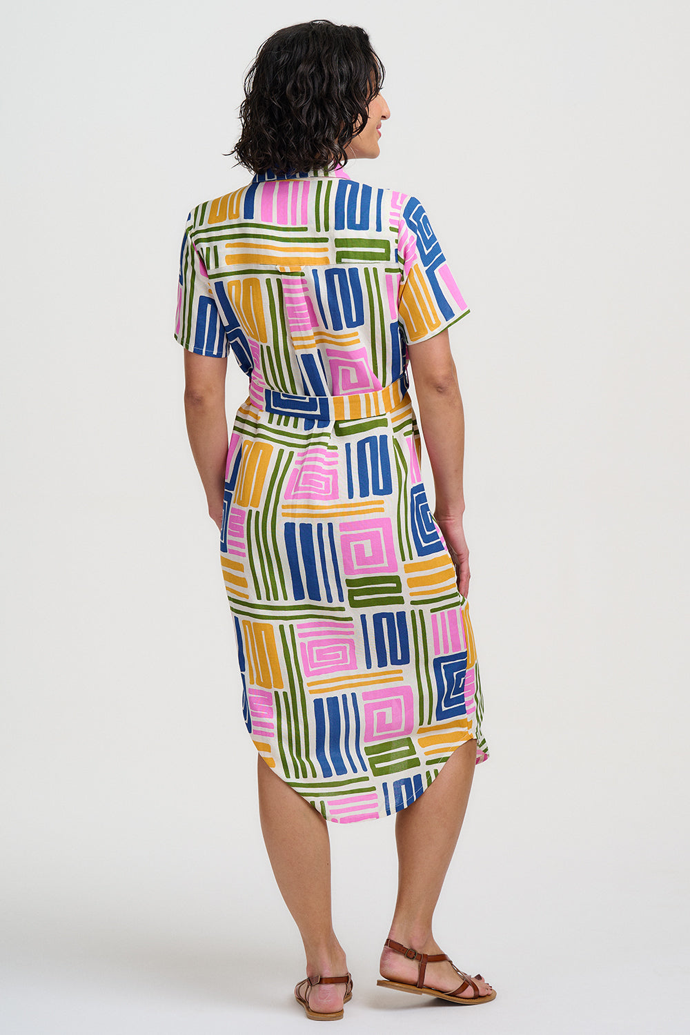 Woman wearing a colorful geometric patterned dress on a white background