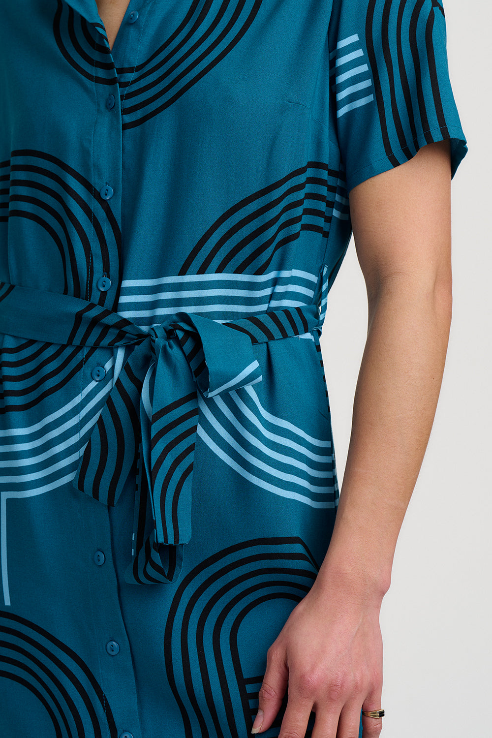 Teal dress with black and white abstract pattern on a plain background
