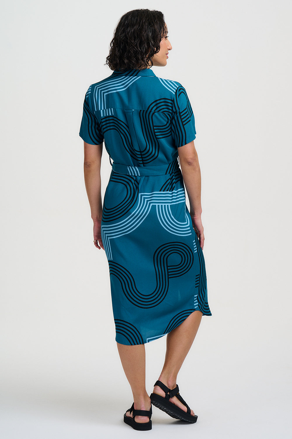 Woman wearing a blue dress with a geometric pattern on a white background