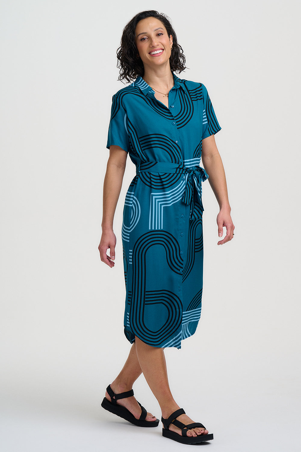 Woman wearing a blue dress with a geometric pattern on a white background