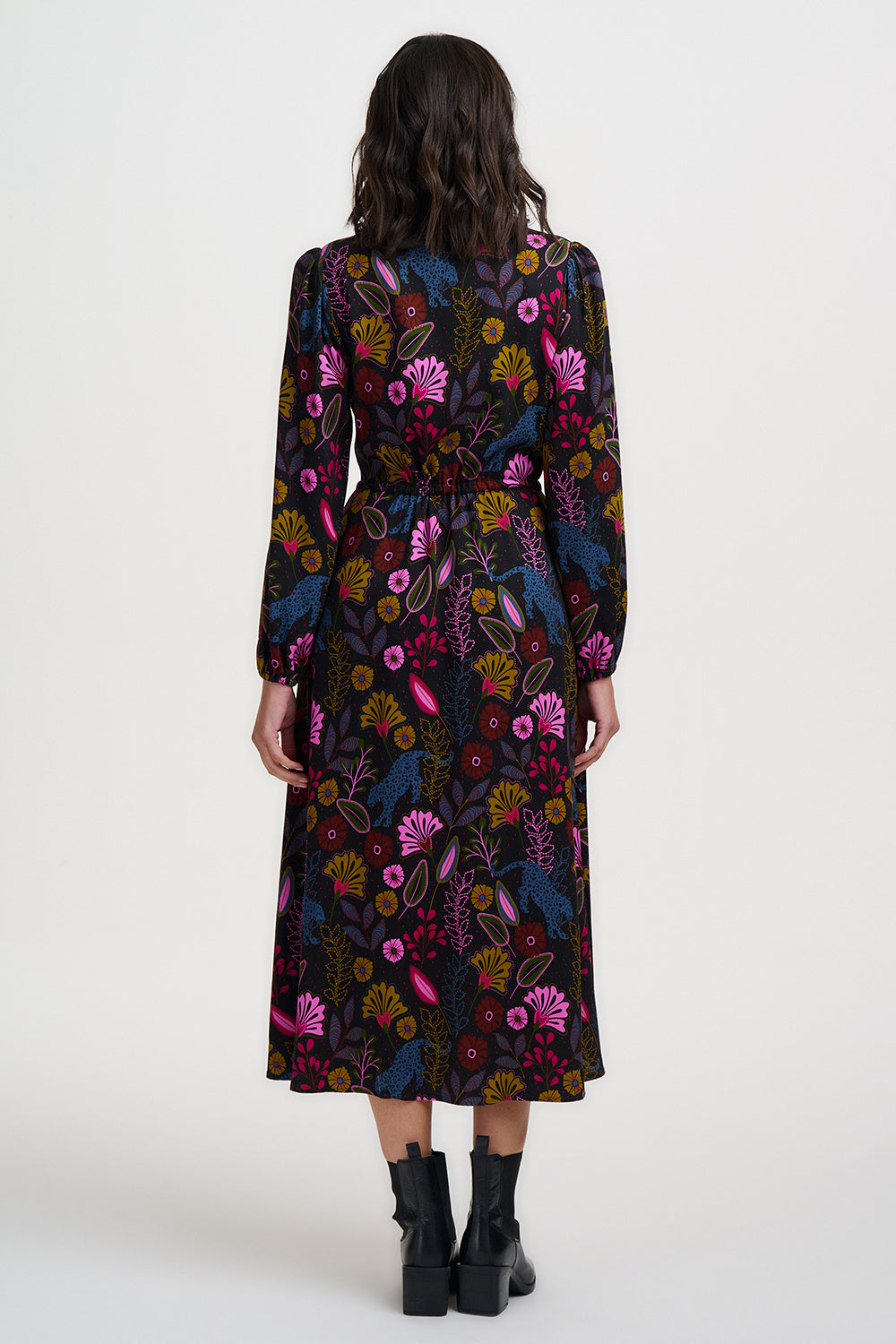 Woman wearing a long, dark floral dress on a white background