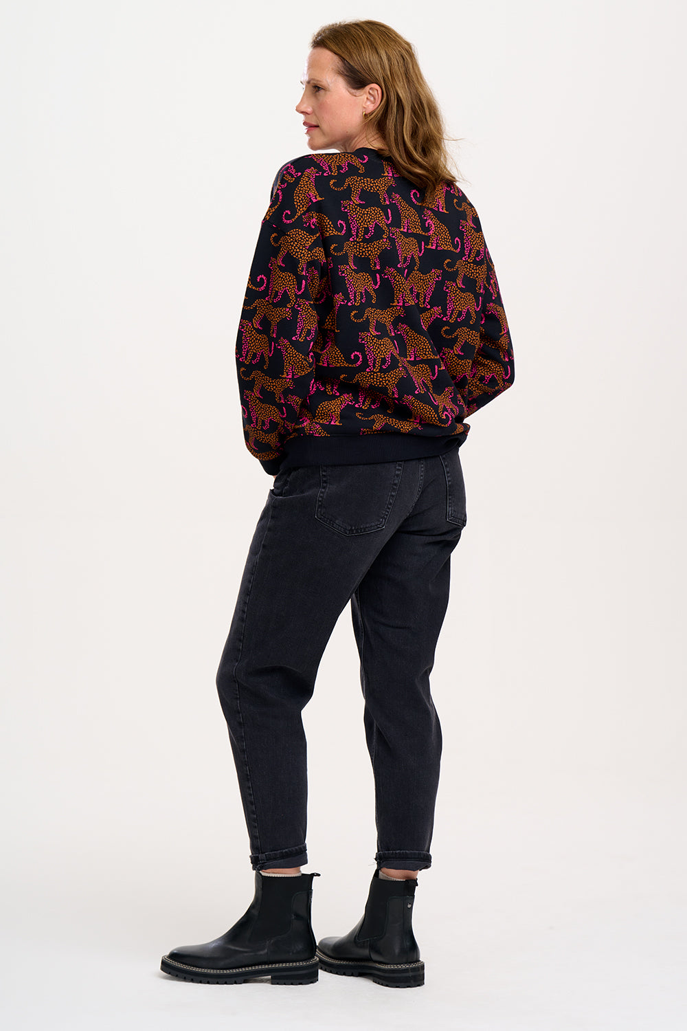 A Sugarhill Brighton model wearing a black sweatshirt with a two-tone leopard print pattern, paired with black trousers.