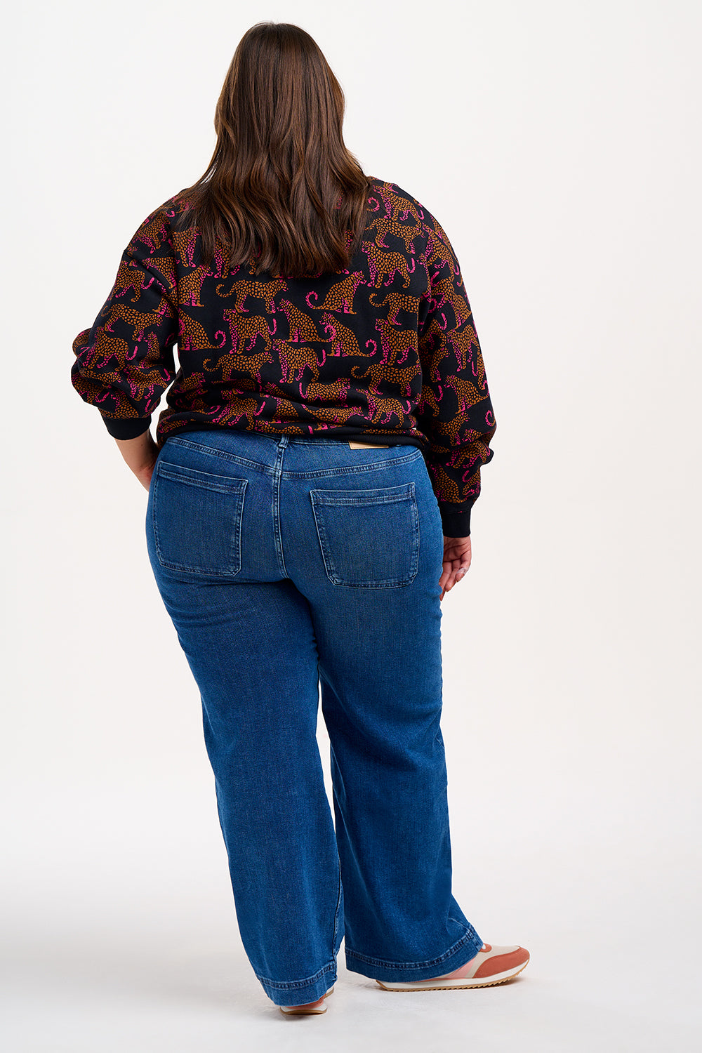 A Sugarhill Brighton model wearing a black sweatshirt with a two-tone leopard print pattern, paired with black trousers.