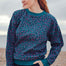 Woman wearing a patterned sweater standing on a beach
