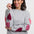 Woman wearing a gray sweater with pink heart patterns on a white background