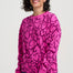 Woman wearing a pink sweatshirt with black heart patterns on a white background