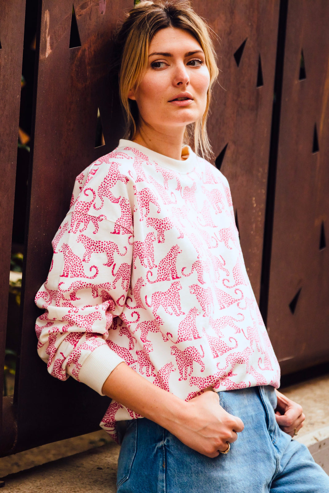 woman modeling white sweatshirt with pink leopards on