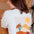Person wearing a white sweatshirt with a desert landscape graphic on the back.