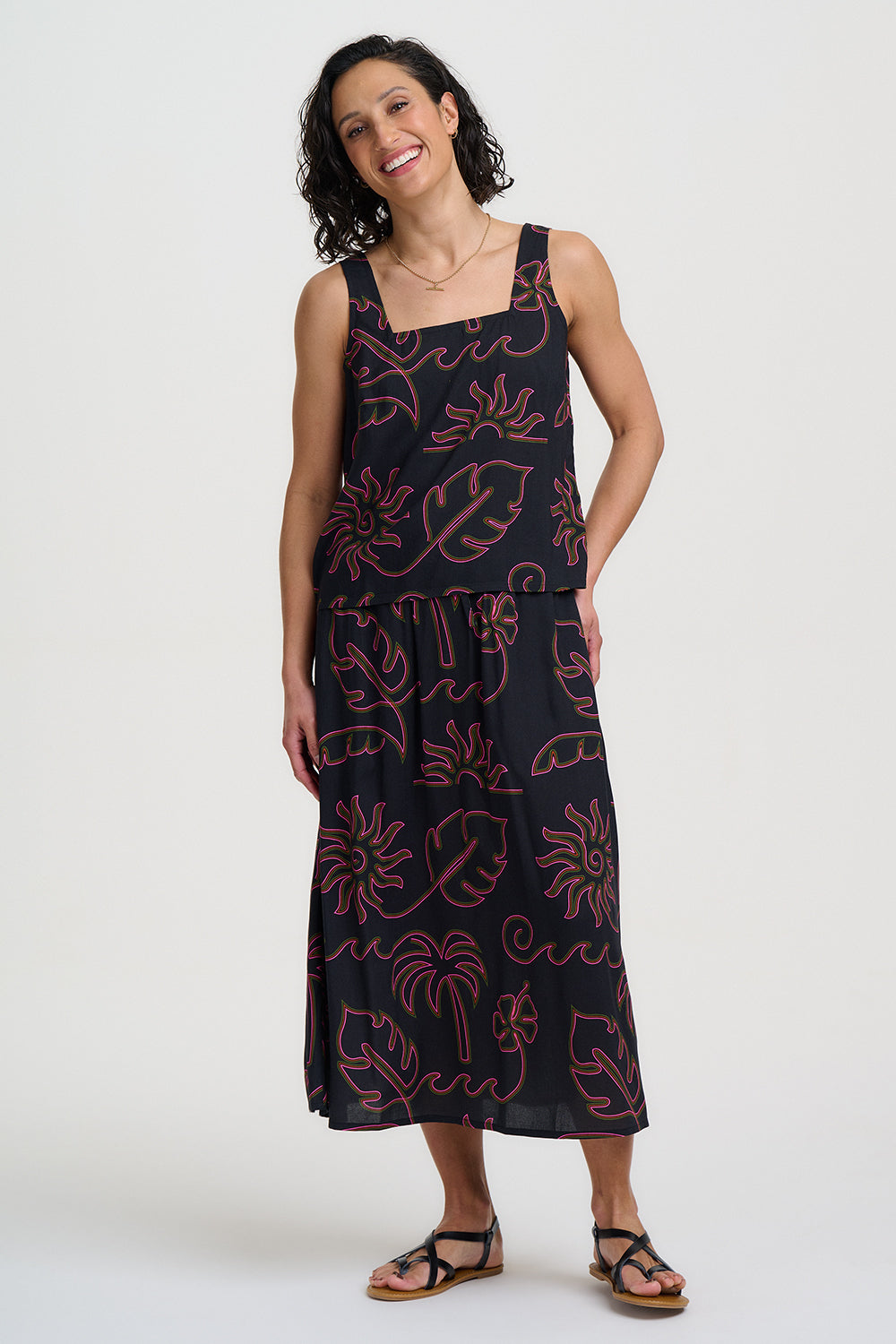 Woman wearing a black dress with red floral patterns on a white background