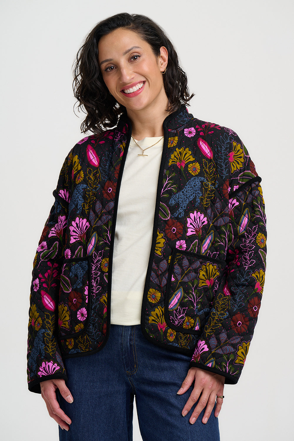 Woman wearing a colorful floral-patterned jacket on a white background